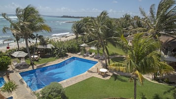 Una piscina con vistas al océano y palmeras.
