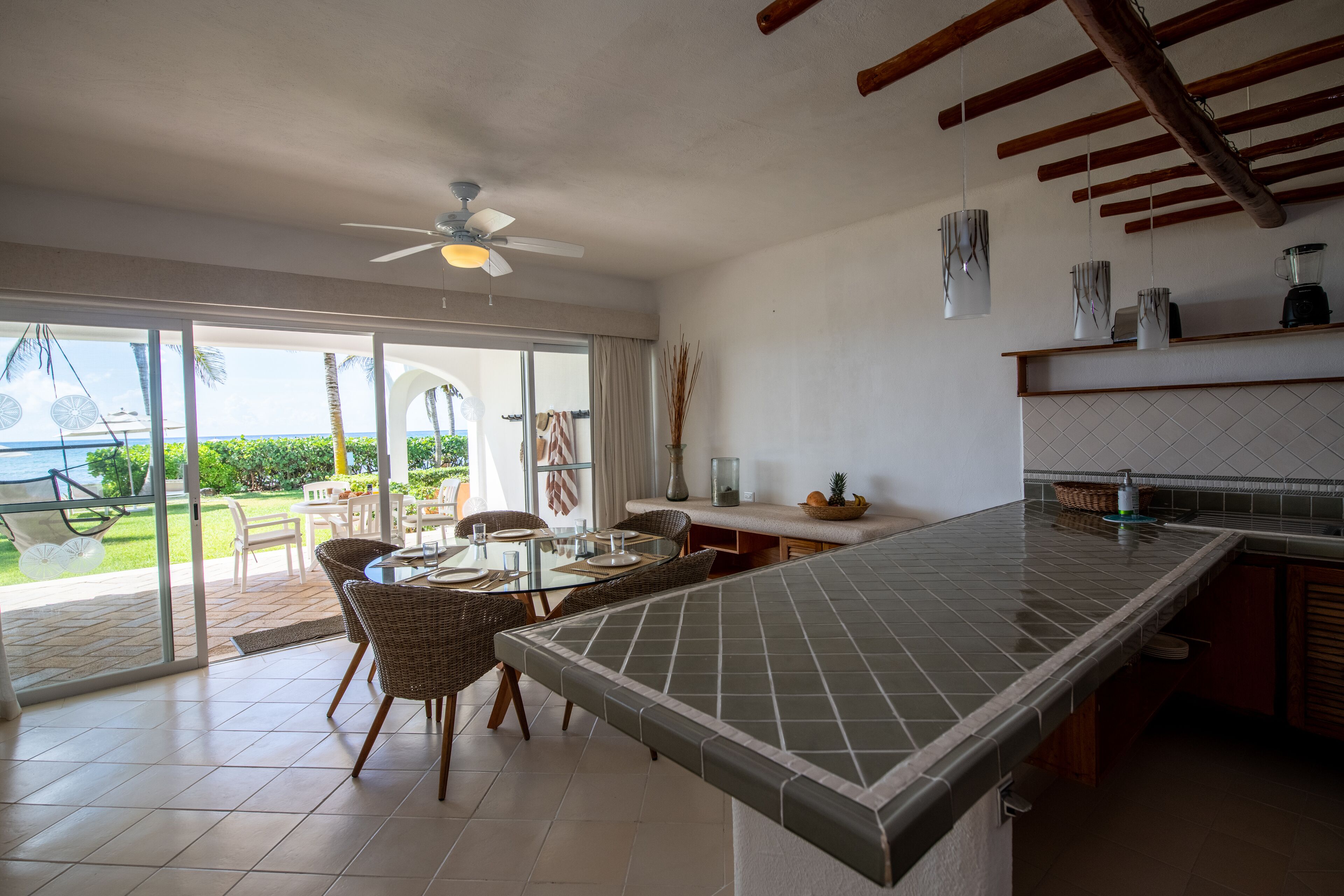 A spacious kitchen with a large island, sliding glass doors leading to a patio, and a ceiling fan.