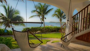 A hammock chair setup overlooking a landscaped garden with palm trees and a view of the sea. - Las Villas Akumal (Akumal)