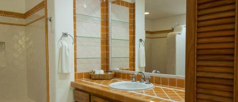 Un bagno con un mobile lavabo in legno, un lavandino e uno spazio doccia.