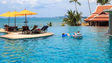 Relax by the ocean with a clear view of the tropical landscape from our pool area, surrounded by lounge chairs and umbrellas.