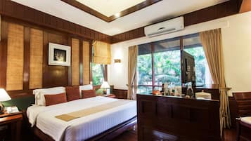 Quarto de hotel com uma cama grande, painéis de madeira, um quadro na parede e uma janela com cortinas.