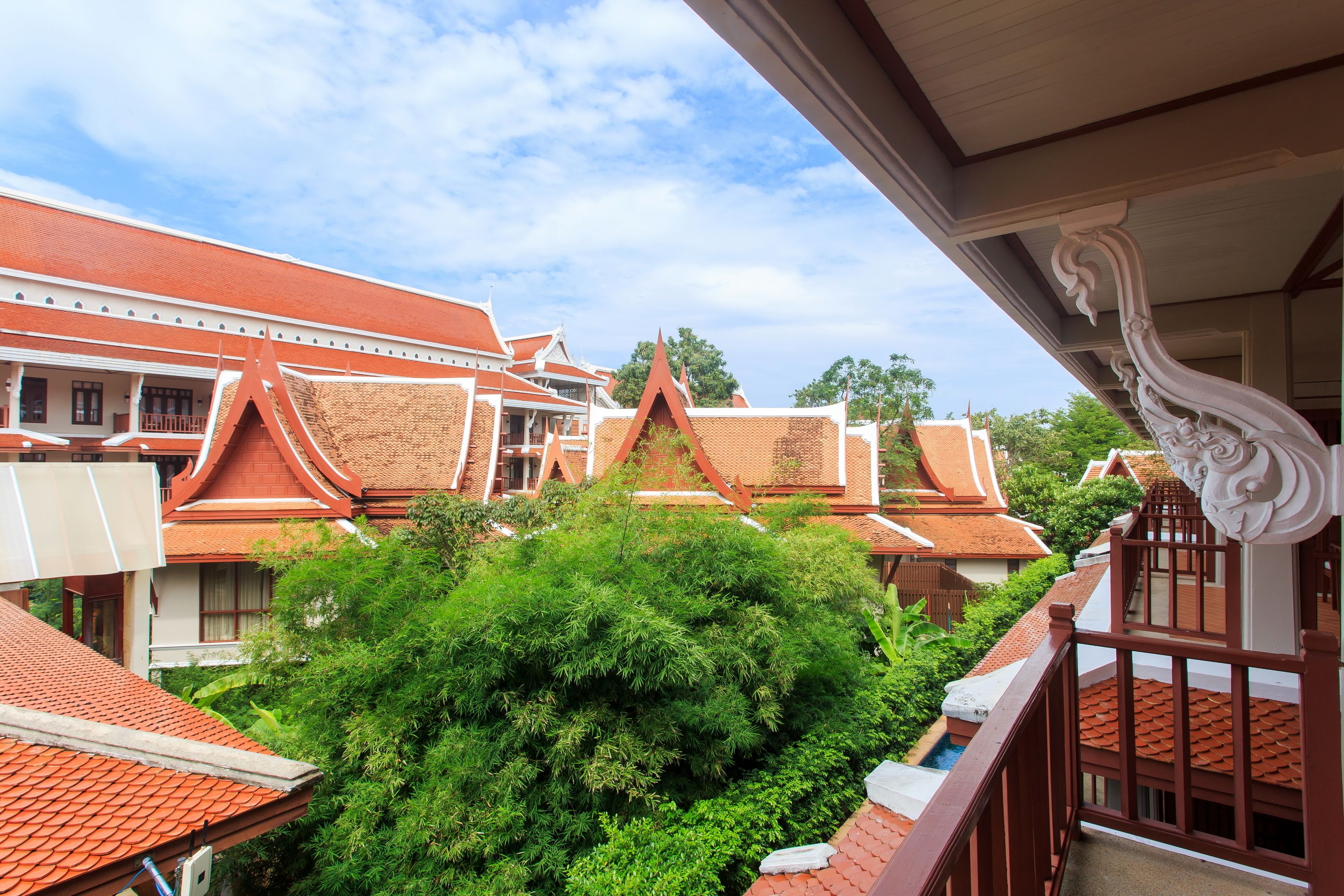 A traditional Thai building with red tiled roofs and ornate architectural details.