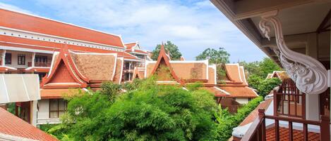 A traditional Thai building with red tiled roofs and ornate architectural details.