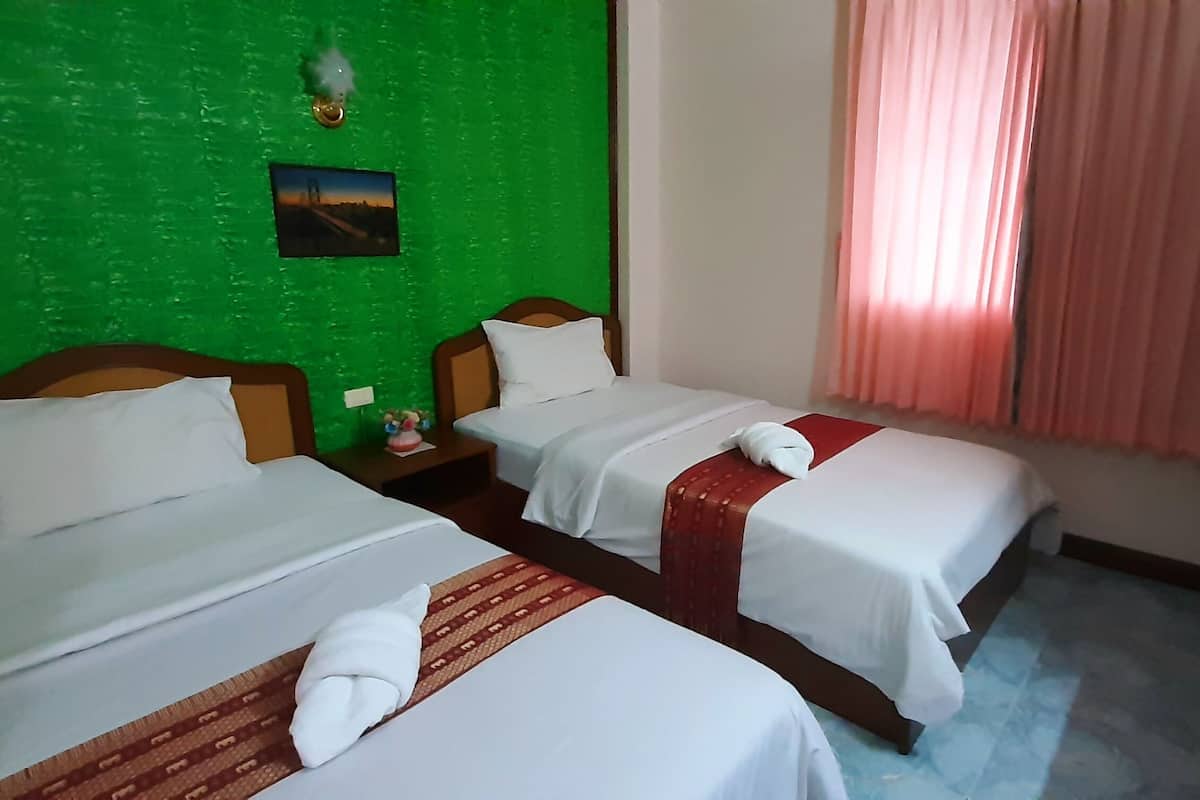 Habitación de hotel con dos camas, paredes verdes, un cuadro en la pared y una ventana con cortinas.