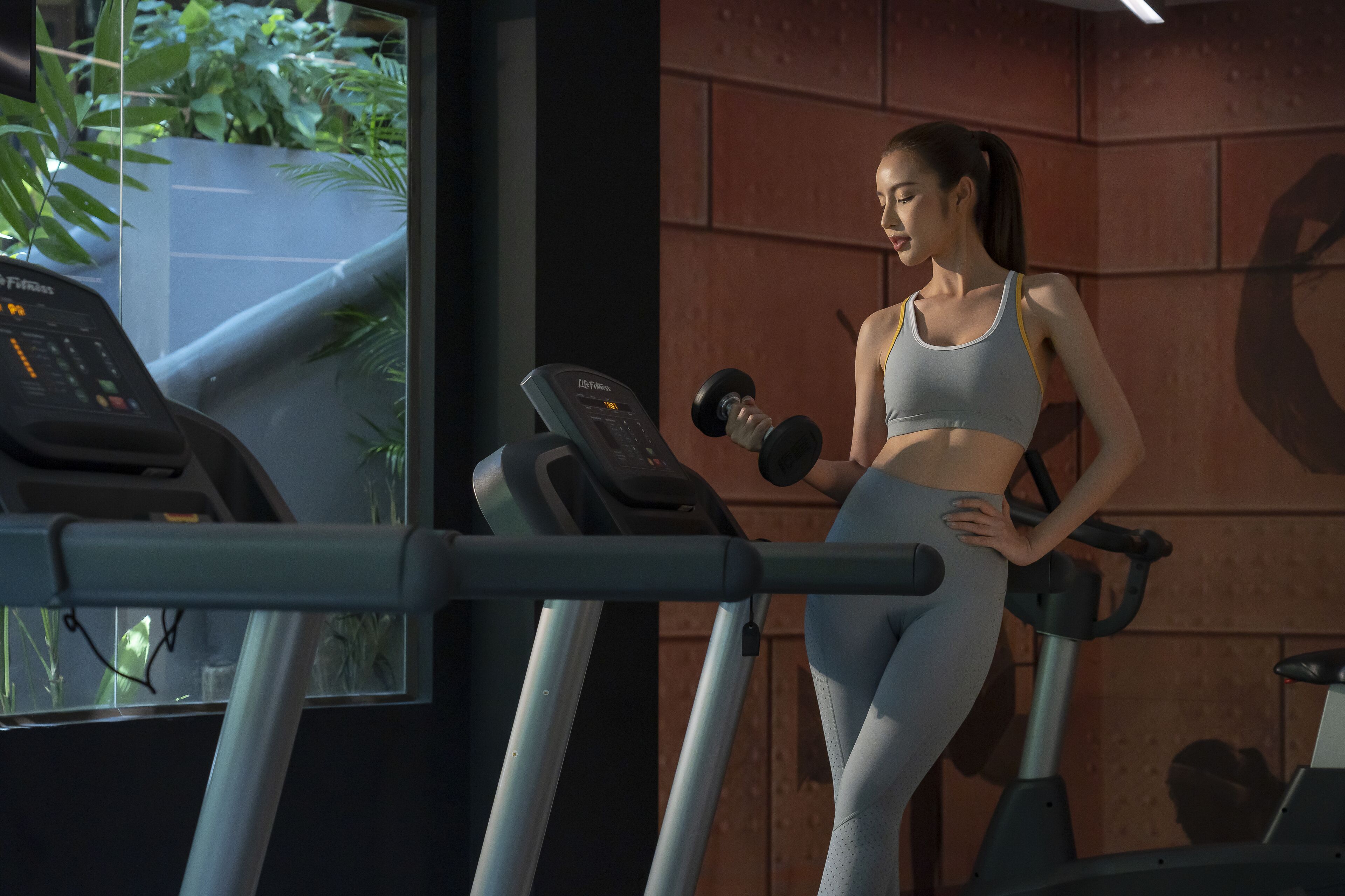 Un gimnasio con equipo de ejercicio, incluyendo una cinta de correr y pesas.
