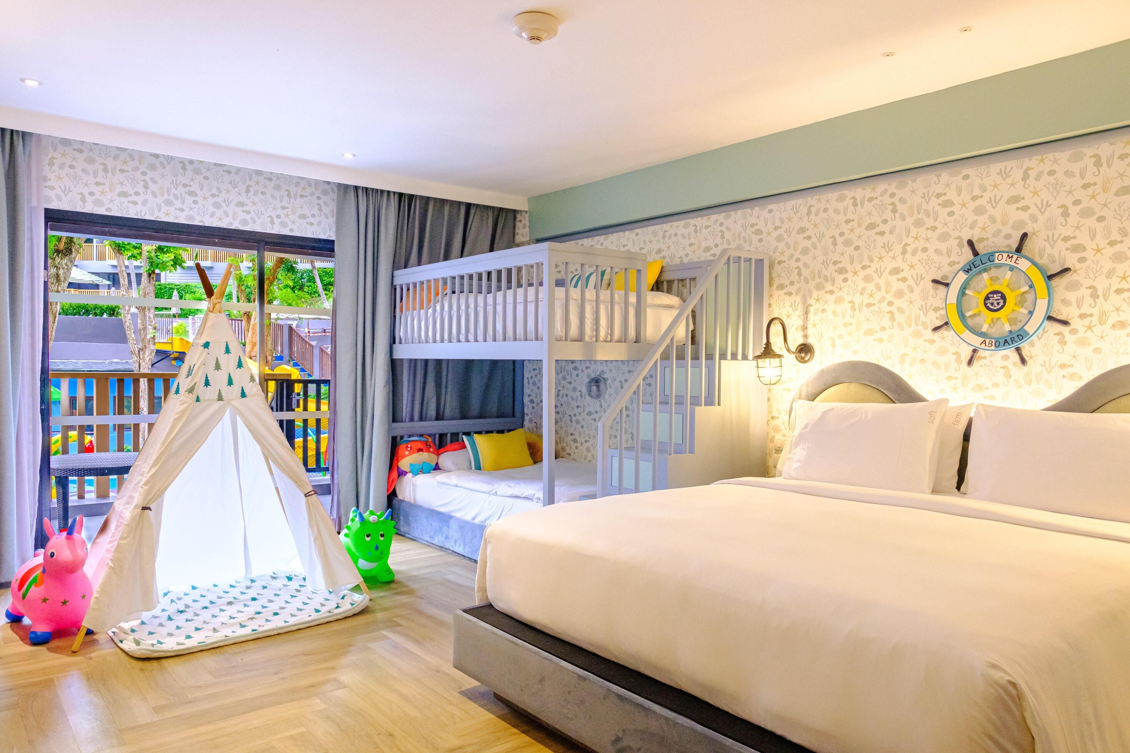 A bedroom with bunk beds, a tent, and a welcome board.