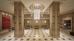 A spacious lobby with a large chandelier, a reception desk, and a patterned wall. - Sheraton Changsha Hotel (Changsha)