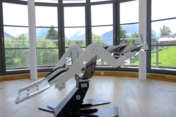 A room with large windows offering a view of mountains and greenery.