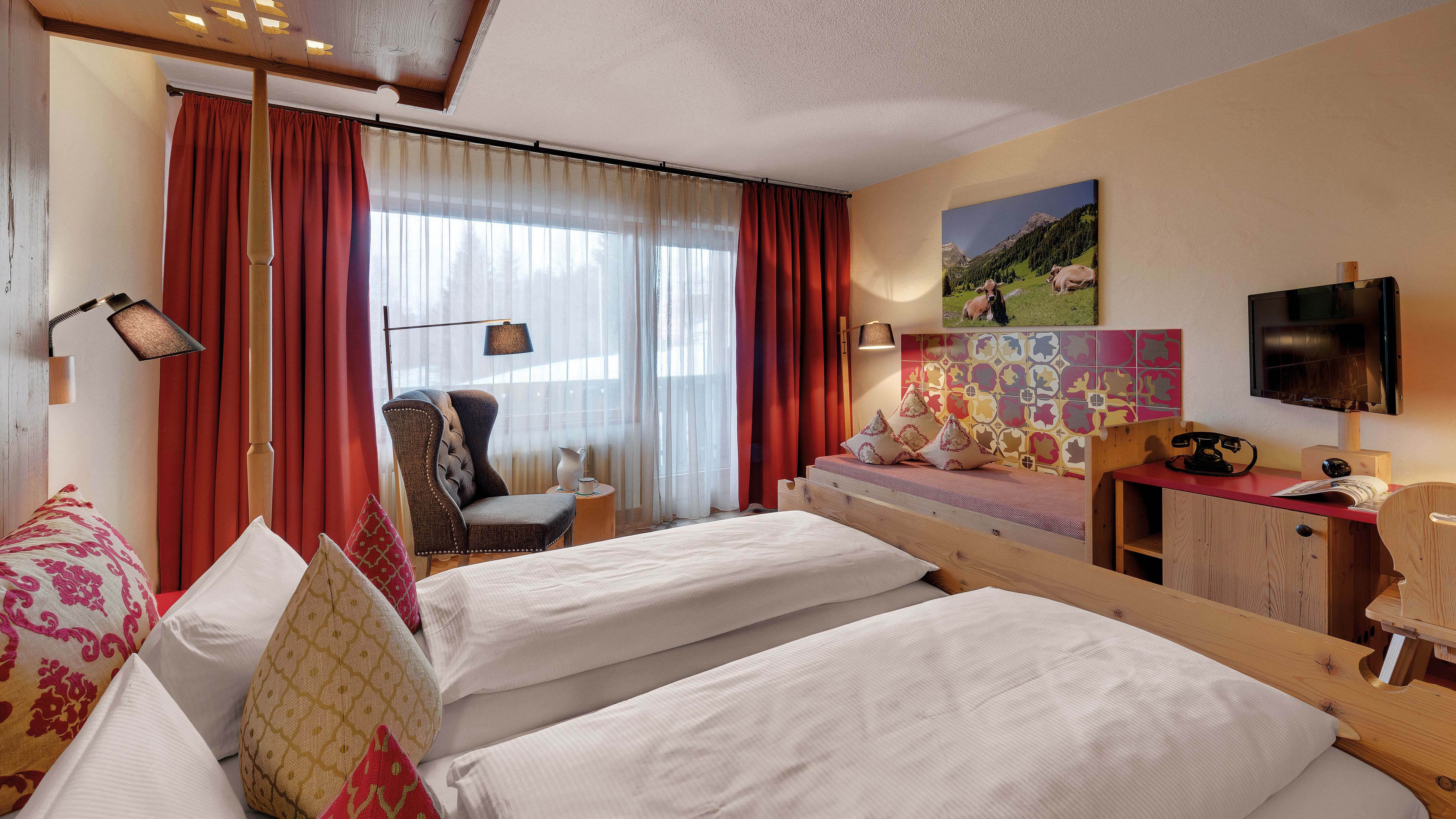 Habitación de hotel con dos camas, una silla, un escritorio, un televisor y un cuadro en la pared.