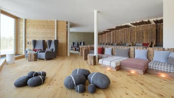 A modern interior with wooden floors, sofas, and chairs arranged in a cozy setting.