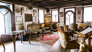 Une pièce au décor traditionnel, avec des poutres en bois, un tapis à motifs et des meubles classiques.