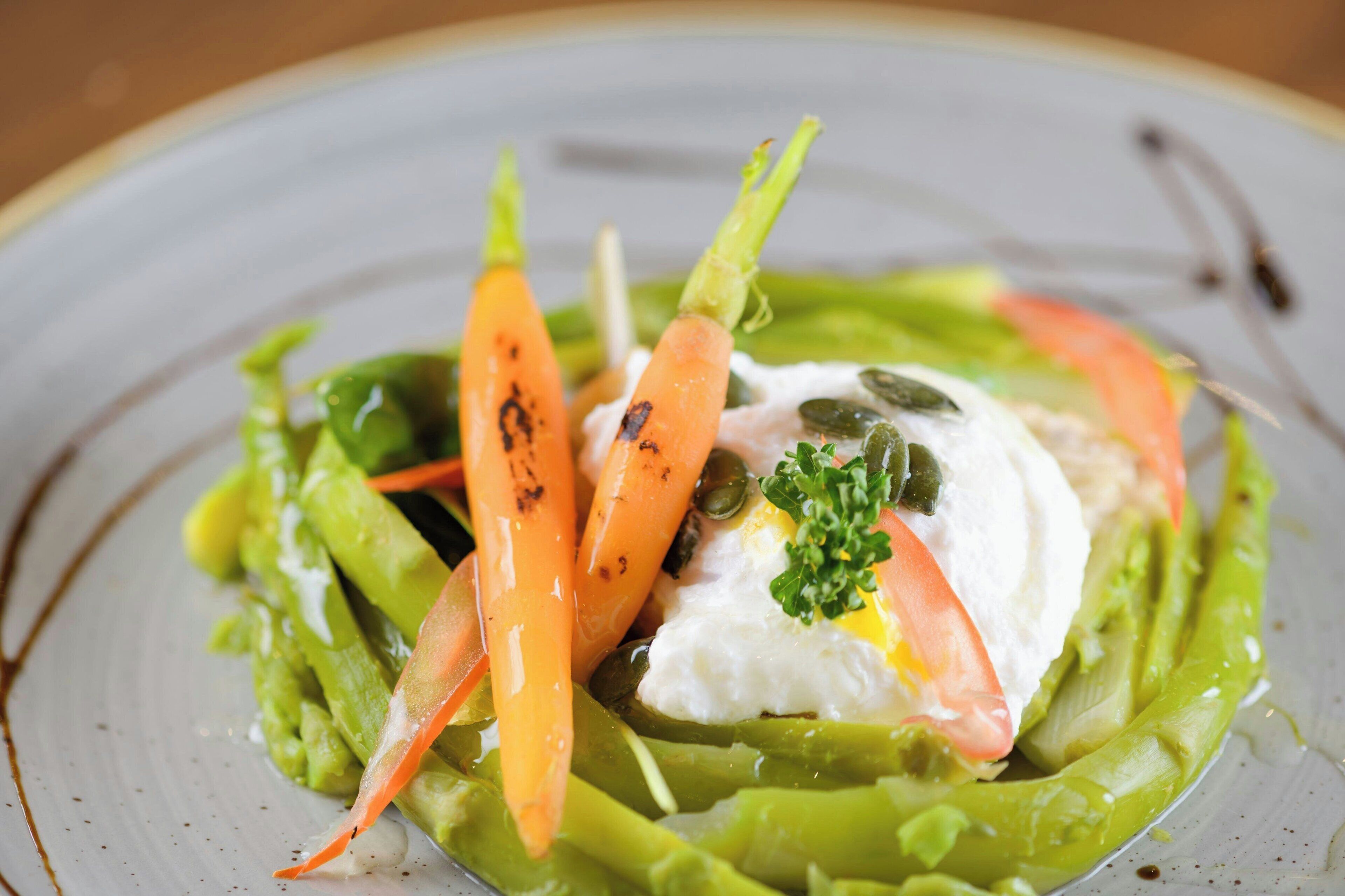 A plate of food with vegetables and a poached egg.