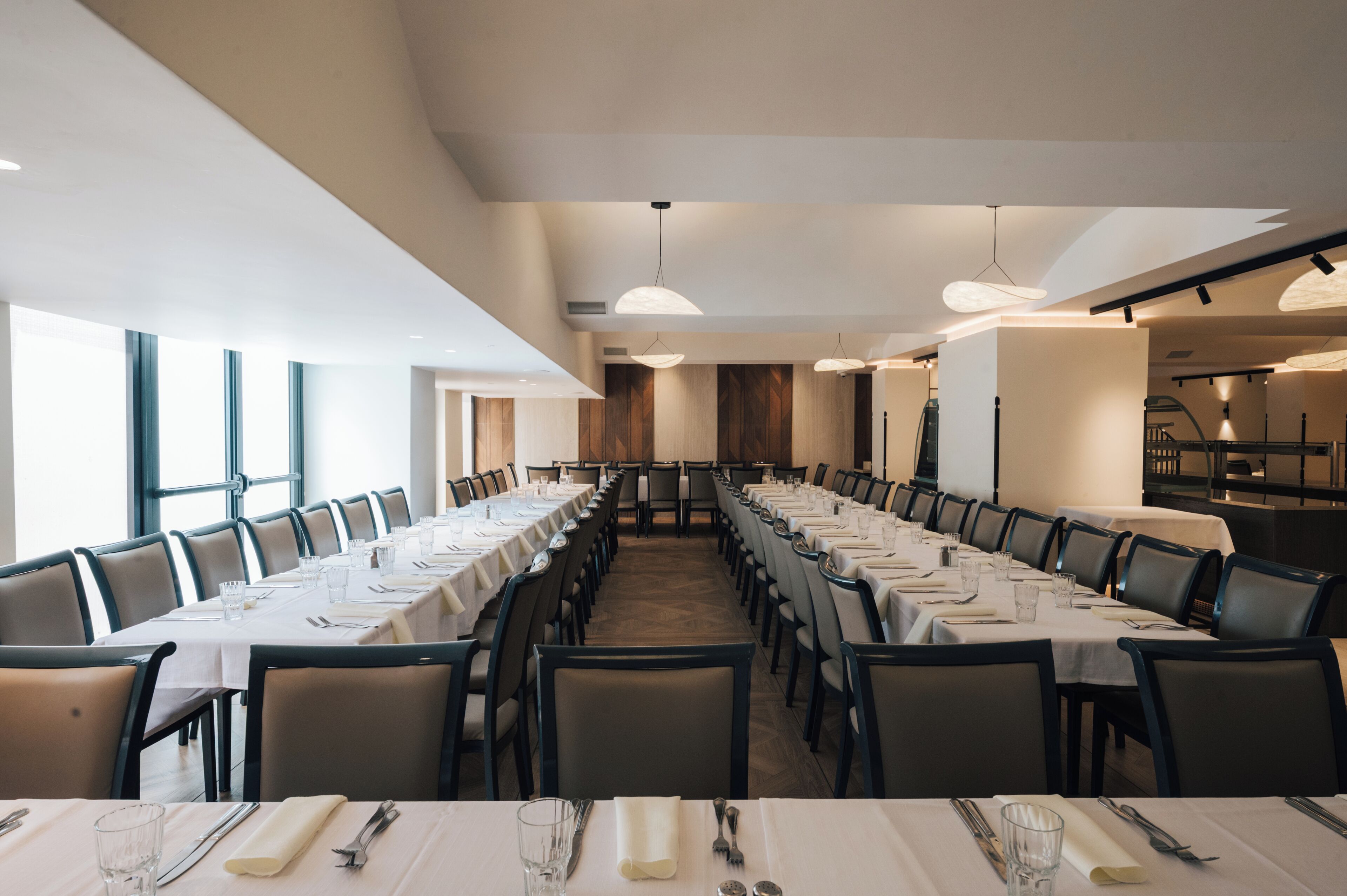 Una larga mesa de comedor con varias sillas, dispuesta para una comida.