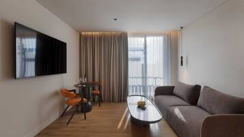 Habitación familiar, varias camas | Zona de estar | Una televisión de pantalla plana