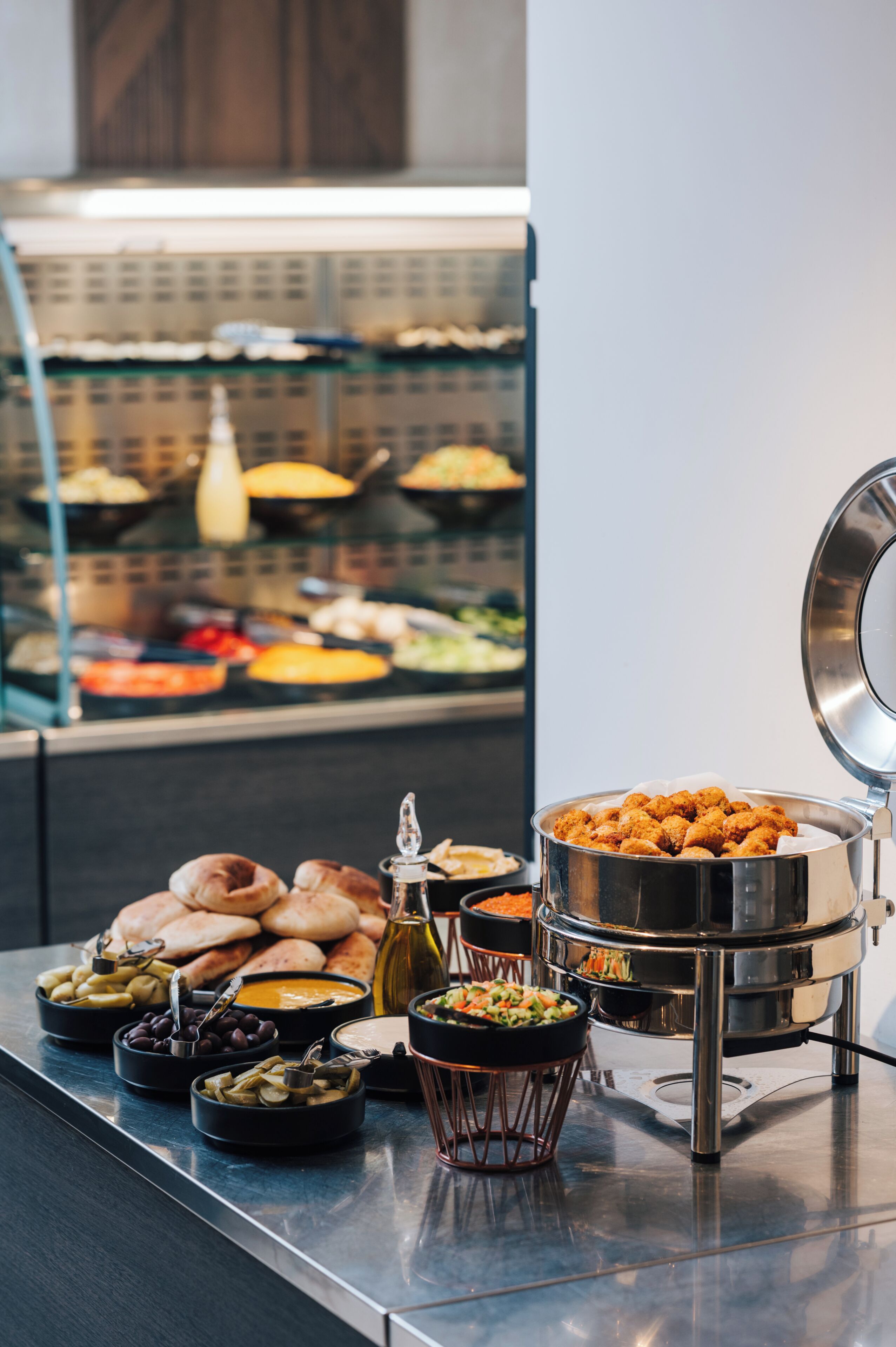 Montaje de bufé con diferentes alimentos y freidora de servicio libre.