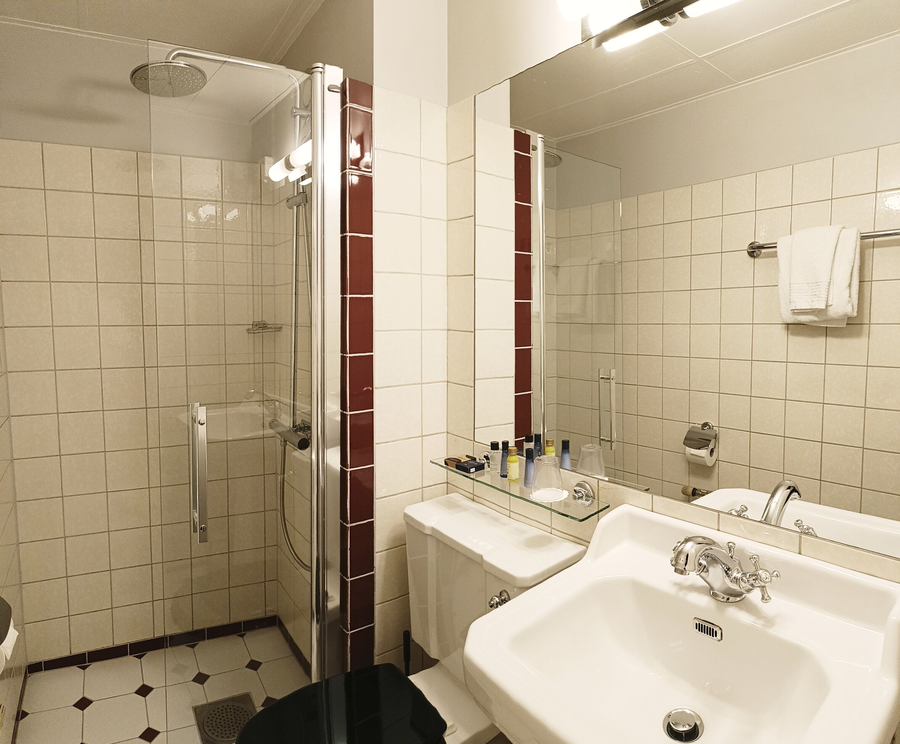 Un baño con ducha de vidrio, un lavabo blanco y un espejo.