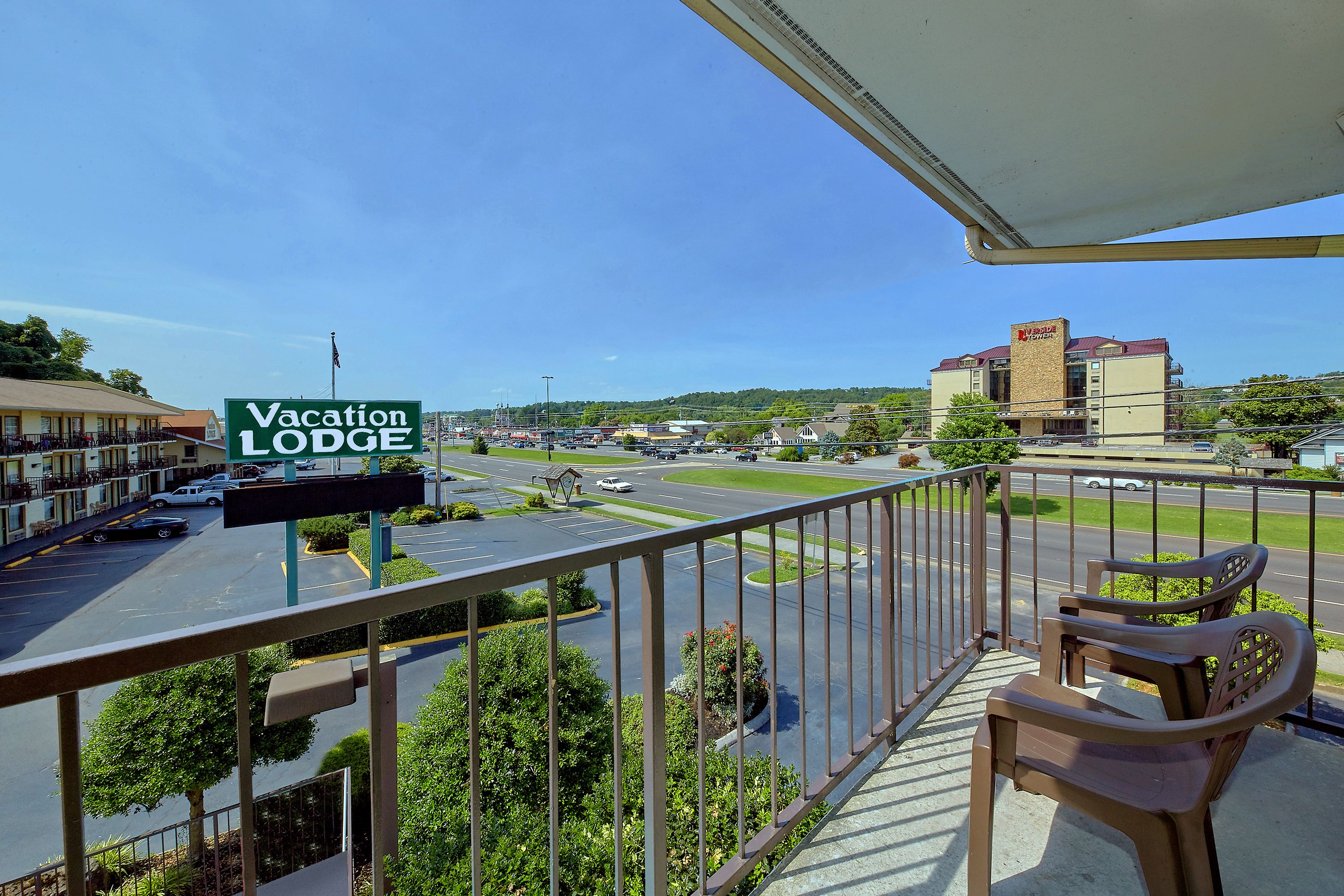 A balcony with a view of a parking lot and a building labeled "Vacation Lodge."
