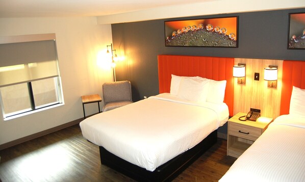 A hotel room with a large bed, a bedside table with a lamp, a chair, and a window.