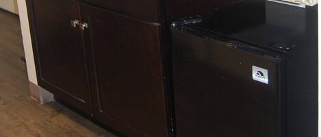A kitchen with a microwave, coffee maker, and a refrigerator.