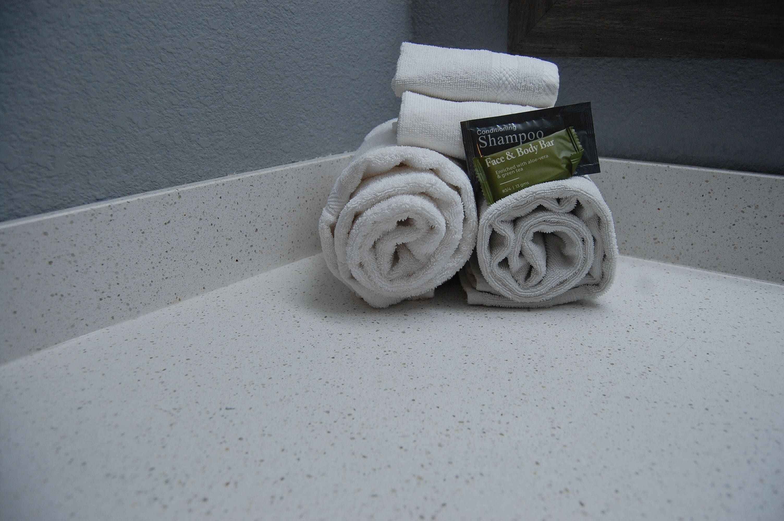 A bathroom with a white sink and a towel with a shampoo bar.