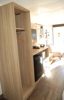 Una cocina moderna con armarios de madera, un lavavajillas negro y una encimera con un teléfono y un electrodoméstico pequeño.