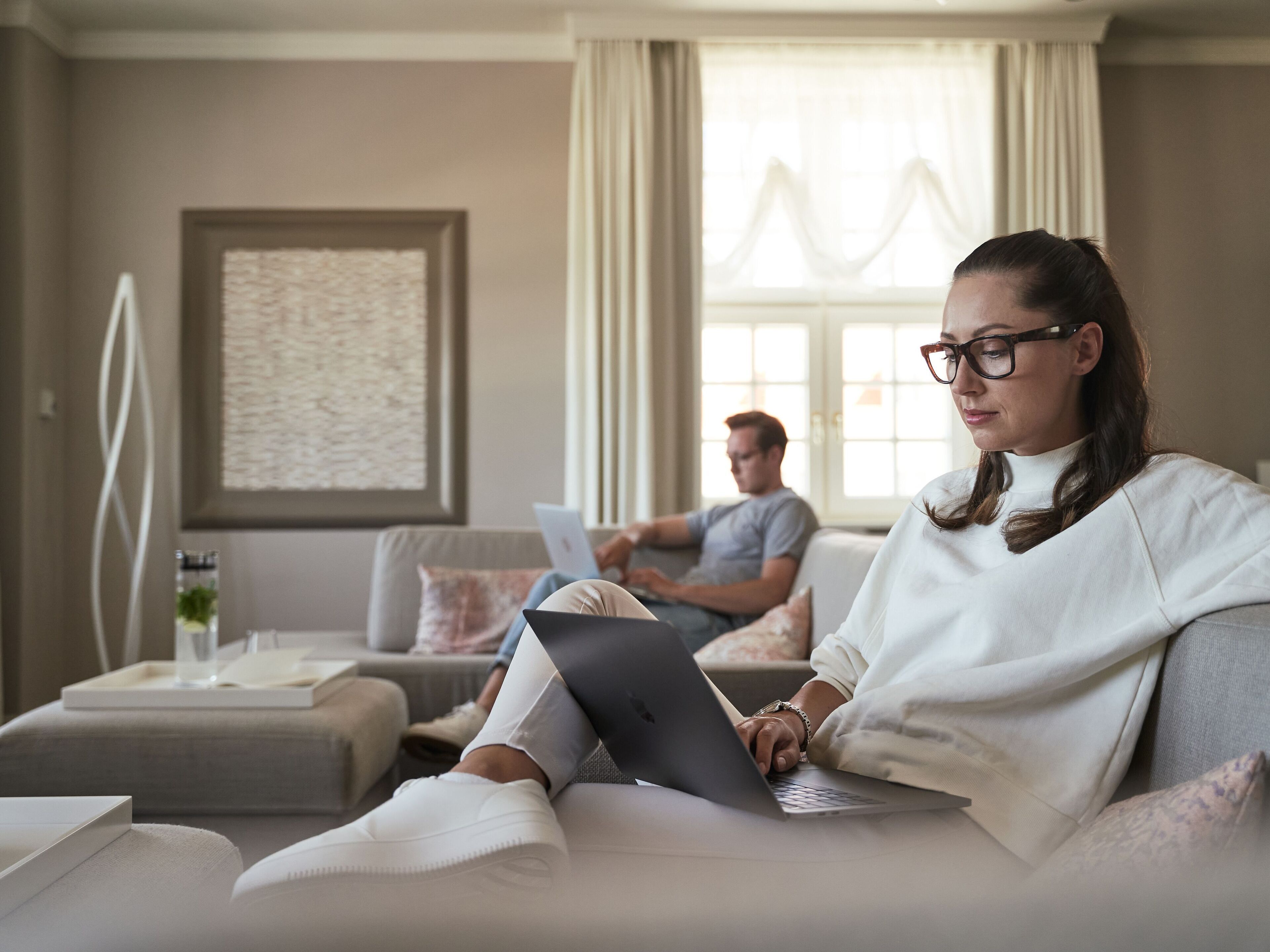 Un salon moderne avec un canapé, une table basse et un ordinateur portable.
