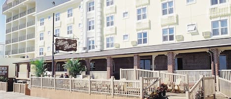 A hotel with a prominent dome structure, multiple balconies, and a wooden boardwalk leading to the entrance.