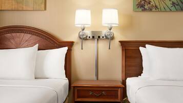 A hotel room with two beds, a nightstand with a drawer, and two wall-mounted lamps.