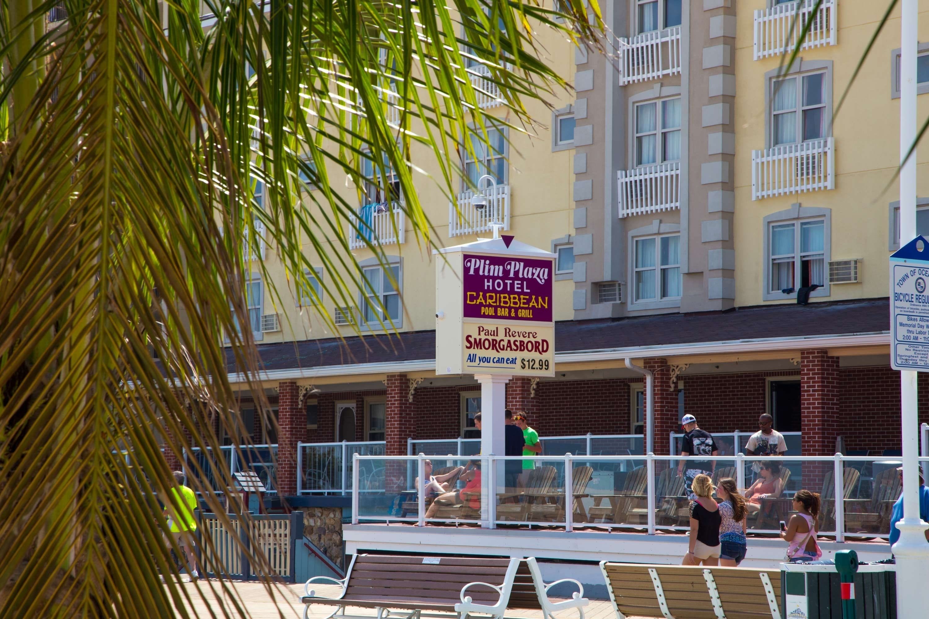 Un hotel con un cartello pubblicitario di un bar e griglia a bordo piscina, e il prezzo di 12,99 dollari.