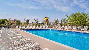 A swimming pool with lounge chairs and a sign for 'Plim Plaza Resort Hotel'.
