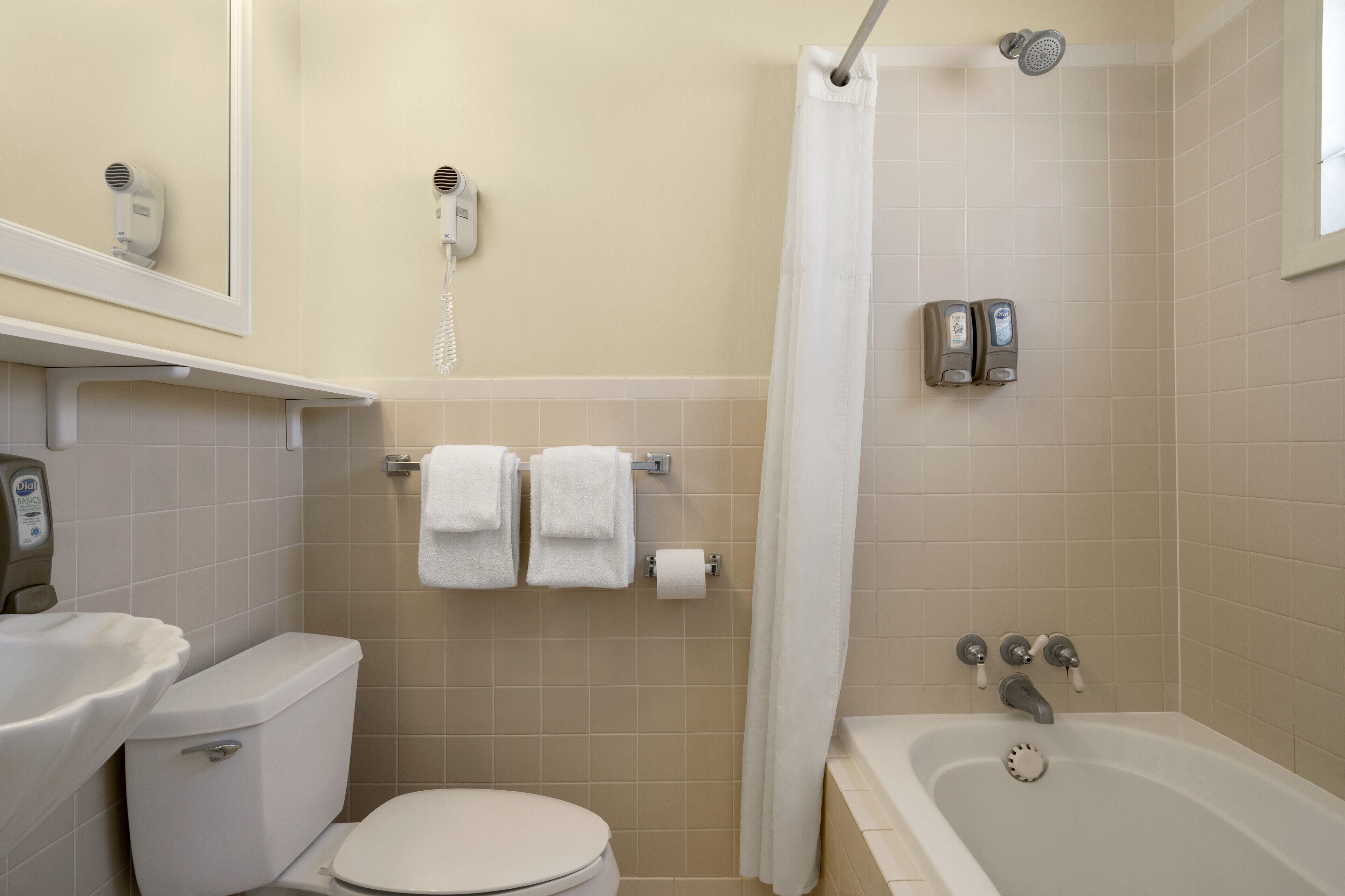 Ein Badezimmer mit Toilette, Waschbecken, Dusche und Handtuchhalter.