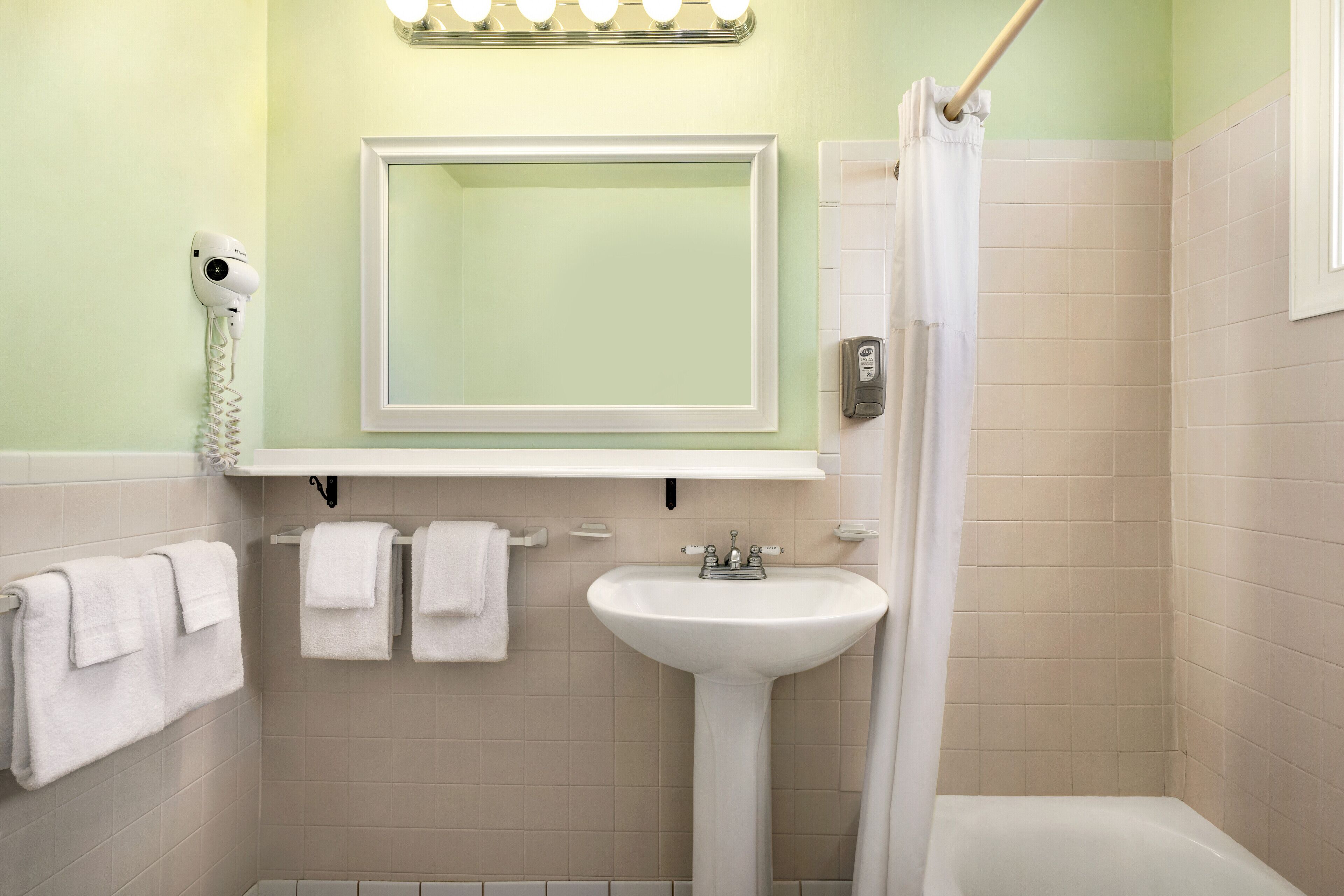 A bathroom with a sink, mirror, and towel rack.
