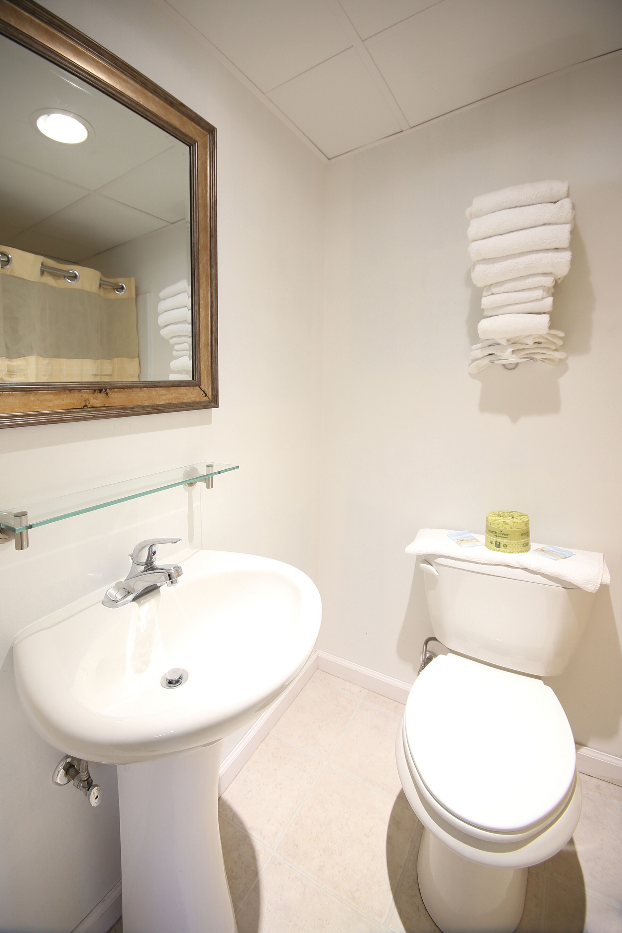 A bathroom with a white sink, a mirror, and a toilet.