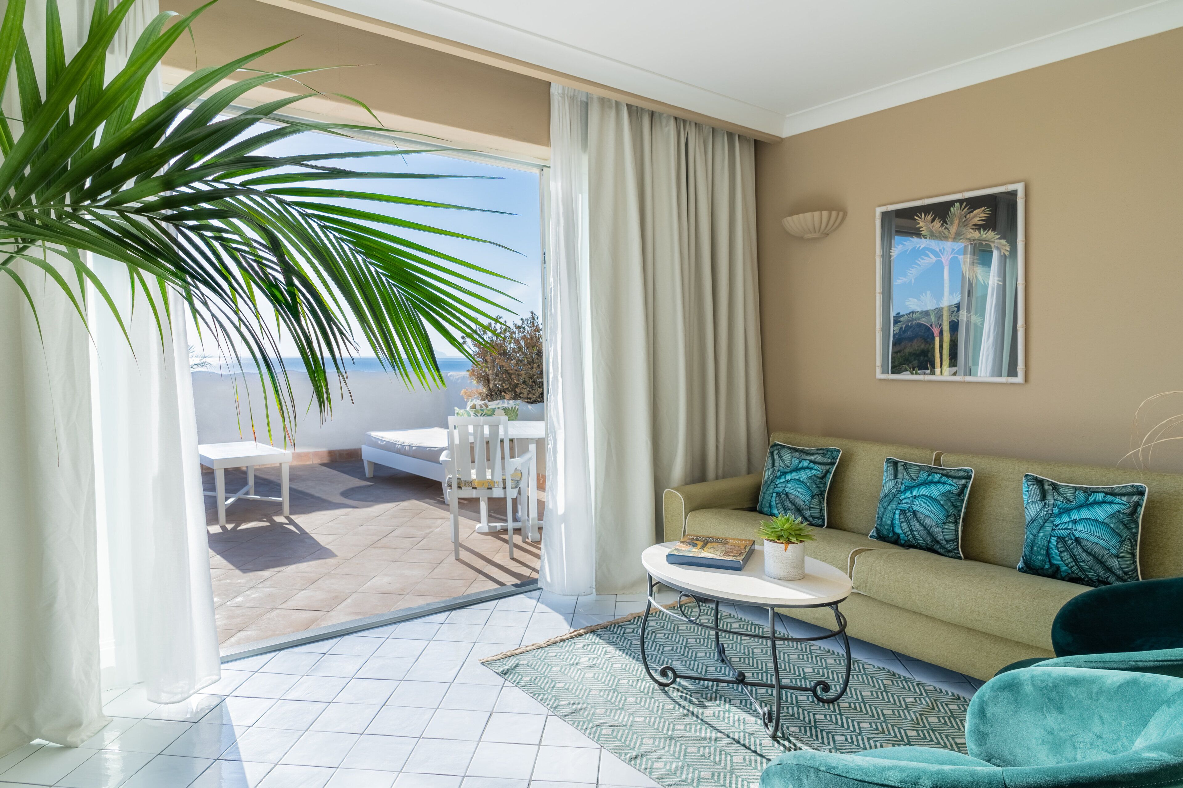 A modern living room with a sofa, a coffee table, and a view of the outdoors.