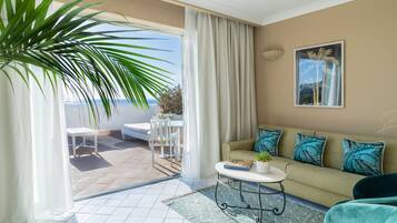 A modern living room with a sofa, a coffee table, and a view of the outdoors.