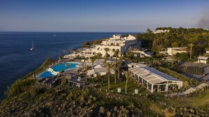 Une station balnéaire dotée d’une piscine, de plusieurs villas et offrant une vue sur la mer.