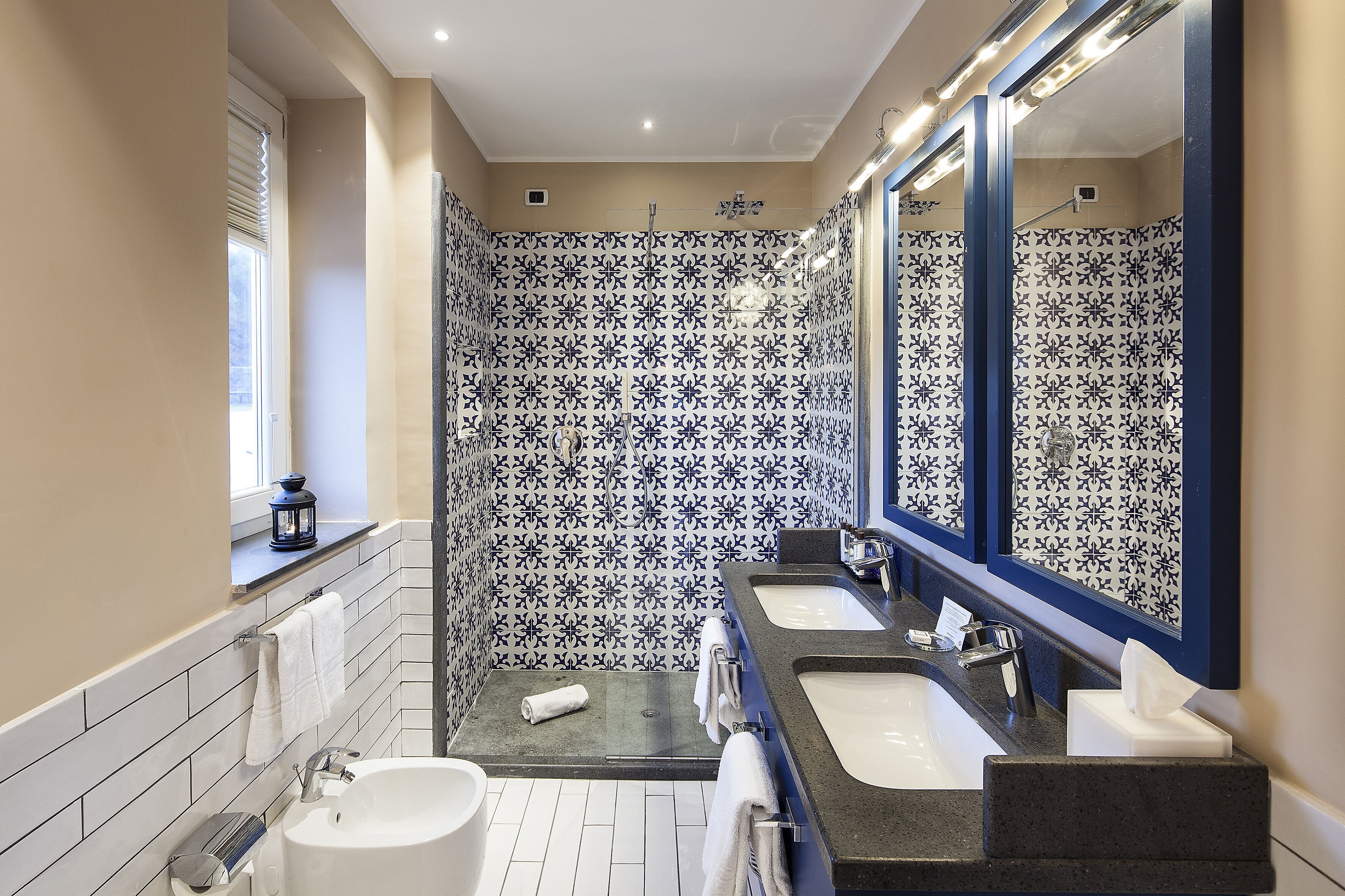 A modern bathroom with two sinks, a bathtub, and a shower area.