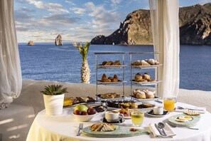 Enjoy a leisurely breakfast with a view of the sea and rocky cliffs.