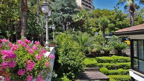 Um jardim exuberante com diversas plantas e um candeeiro.