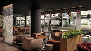 Een moderne lounge met banken, een koffiebar en grote ramen.