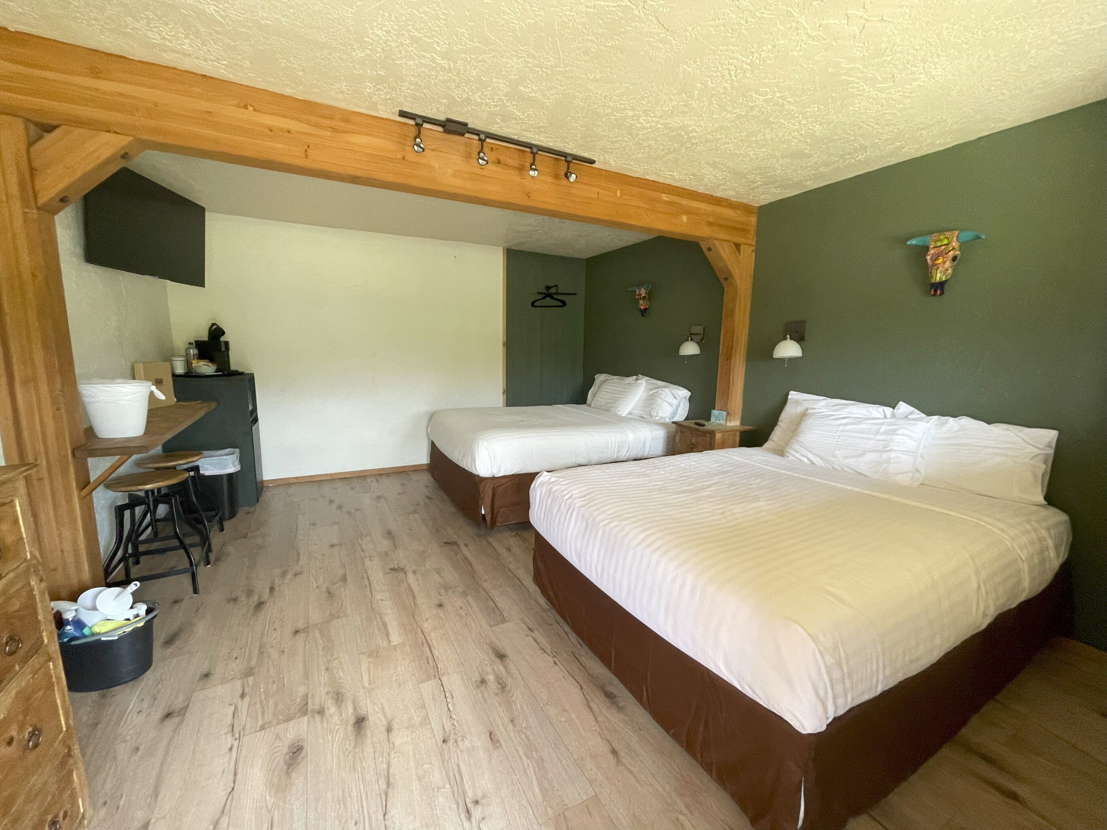 Una habitación con dos camas, un escritorio y una silla.