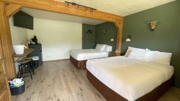 A room with two beds, a desk, and a chair.