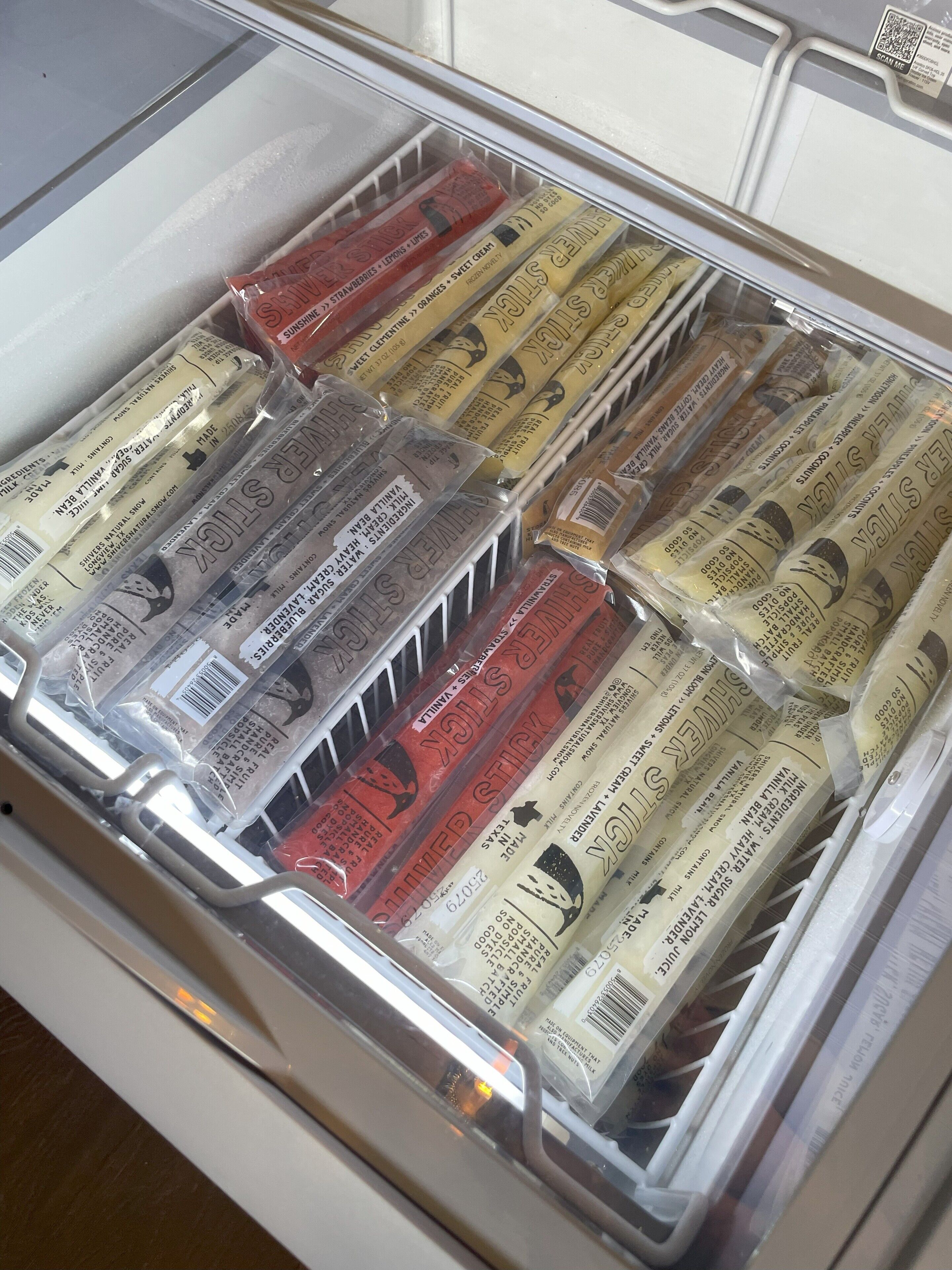 Un refrigerador lleno de diversos alimentos congelados.