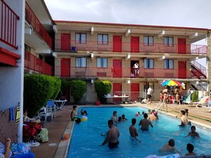 Ein Hotel mit mehreren Balkonen, einem Swimmingpool und Außenbereich-Sitzgelegenheiten.