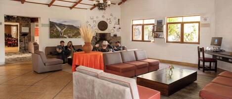 Un vestíbulo amplio con techos altos, una chimenea y una zona de estar con sofás y una mesa de centro.