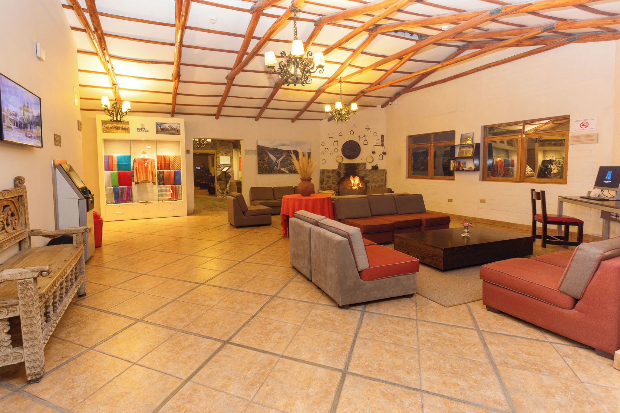A spacious lobby with a high ceiling, a fireplace, and a variety of seating arrangements including sofas and a bench.