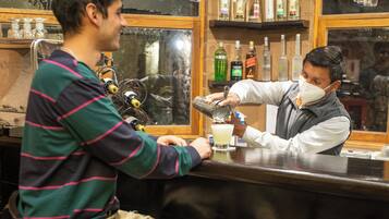 A bar setting with a bartender preparing a drink.