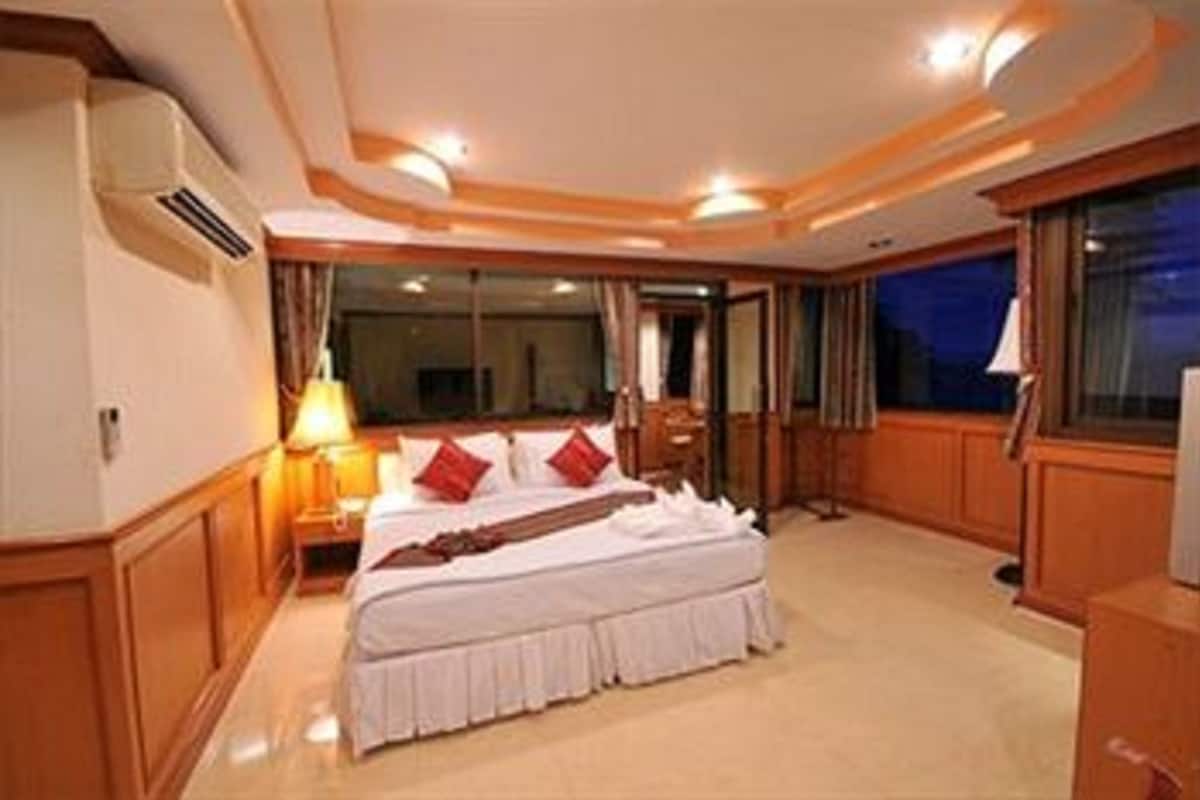 A hotel room with a large bed, a desk, and a view of the night sky.