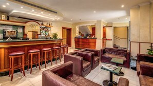 A bar area with stools, a reception desk, and leather seating. - Hotel Osimar (Rome)